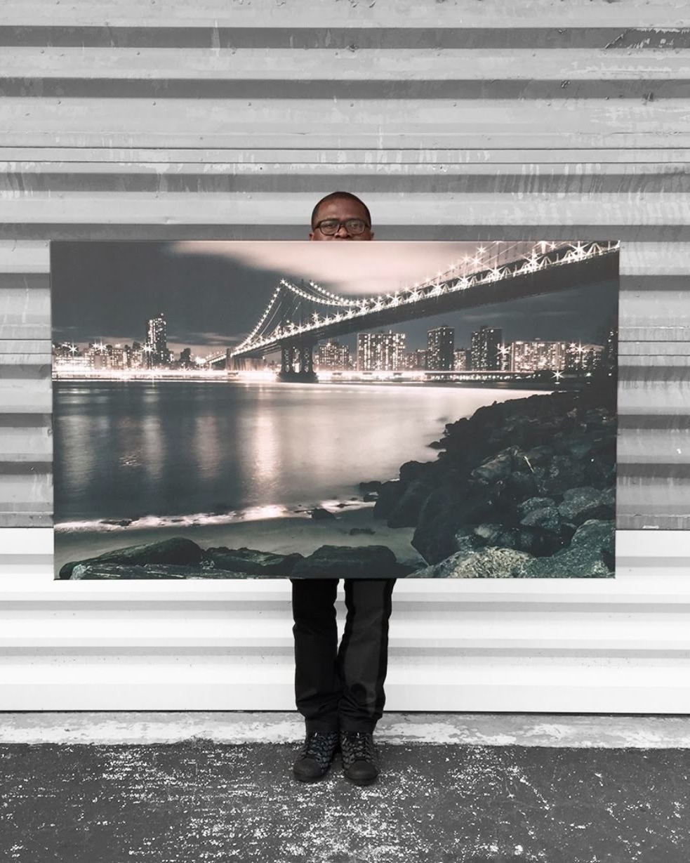 Photographer "Tola" holding a 60x40 Canvas